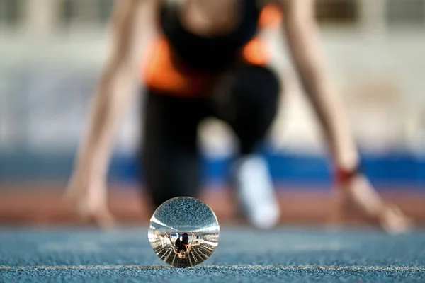 Отражение спортивной женщины в стеклянном шаре во время бега — стоковое фото