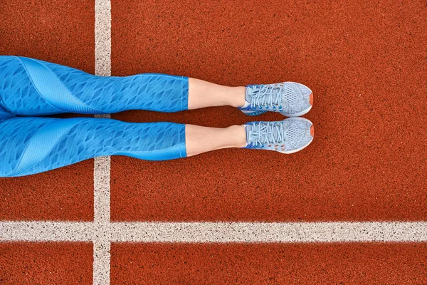 Womans legs lying on colorful open stadium — ストック写真