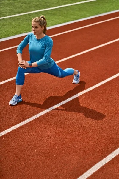 Mulher loira esportiva treinando no estádio aberto — Fotografia de Stock