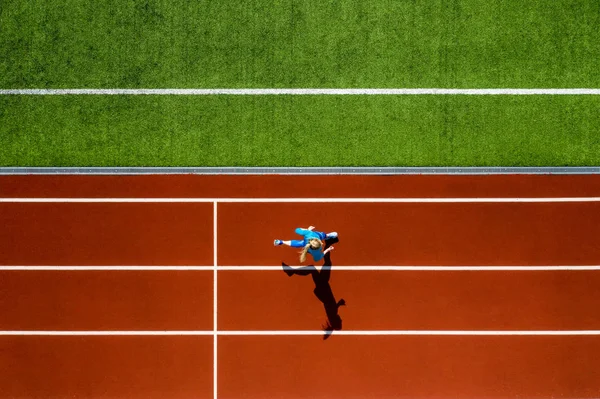 Deportiva mujer rubia corriendo en el estadio abierto — Foto de Stock