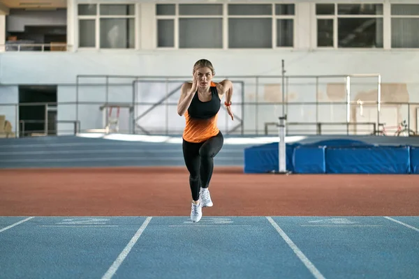 Athletic szőke nő képzés beltéri stadion — Stock Fotó