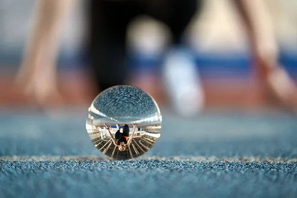 Reflectie van sportieve vrouw in glazen bal tijdens haar hardlooptraining — Stockfoto