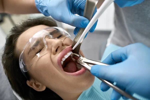 Pretty womans teeth treatment in dental clinic