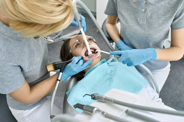 Pretty womans limpieza de dientes en clínica dental —  Fotos de Stock