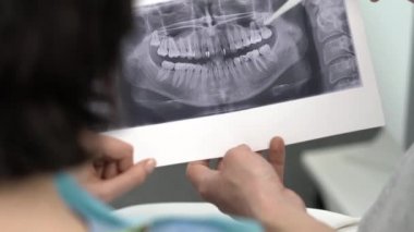 Doktor hastasını diş kliniğine yatırıyor.