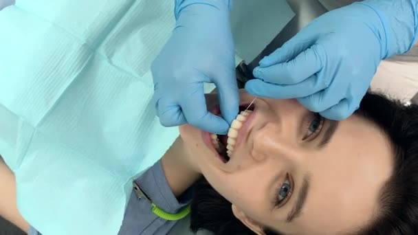 Pretty womans limpieza de dientes en clínica dental — Vídeo de stock