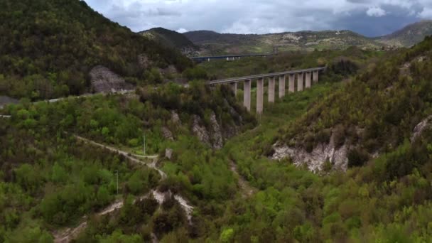Mosty z samochodami nad zieloną górzystą dolinę — Wideo stockowe