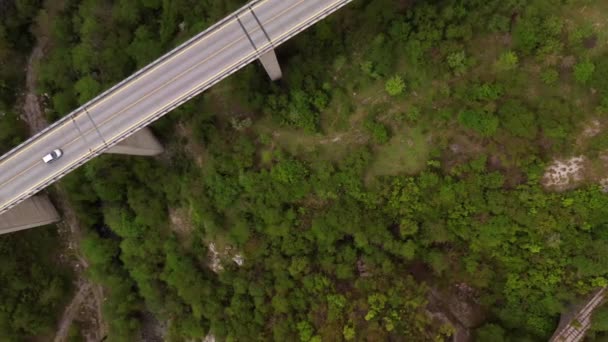 Мост с автомобилем через зеленую холмистую долину — стоковое видео