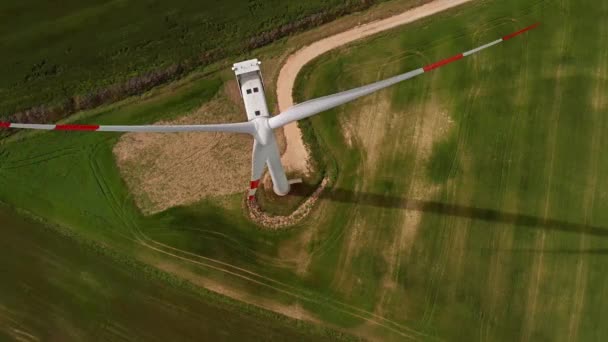 Вид с воздуха на зеленое поле с ветрогенератором — стоковое видео