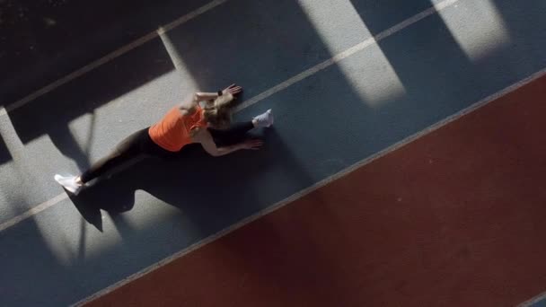 Mujer rubia deportiva entrenando en el estadio interior — Vídeos de Stock