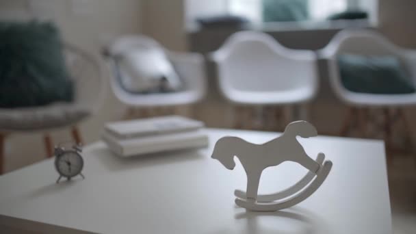 Размахивая винтажной лошадиной игрушкой на столе внутри светлого интерьера — стоковое видео