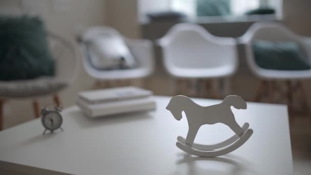 Гойдалки старовинна коняча іграшка на столі всередині світлого інтер'єру — стокове відео