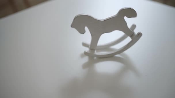 Juguete de caballo vintage ligero oscilante en mesa blanca — Vídeos de Stock