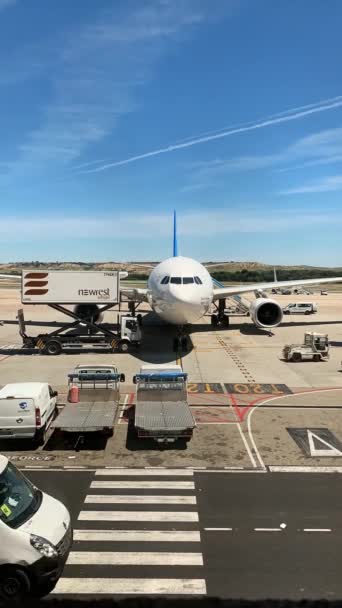 Runway with plane with loading dock in Madrids airport — Stock Video