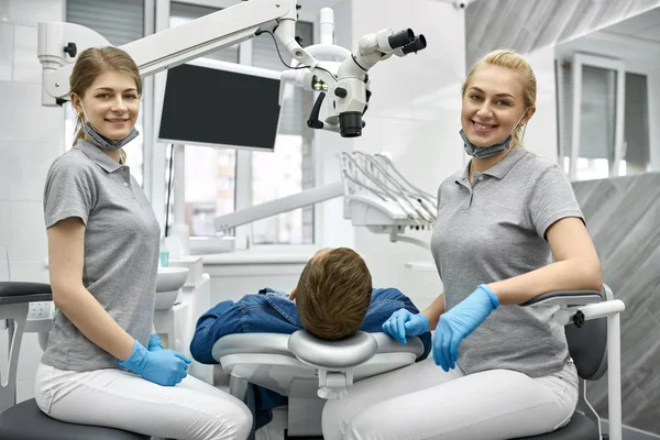 Çalışma sırasında kameraya poz veren neşeli diş hekimleri