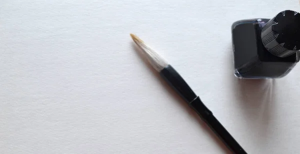 Beyaz üzerine yazı yazmak için fırçayla mürekkep şişesi. — Stok fotoğraf