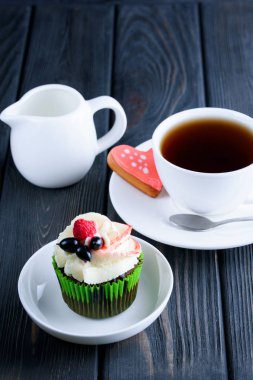 Masanın üzerinde beyaz bir tabak lezzetli kek ile güzel kokulu çay