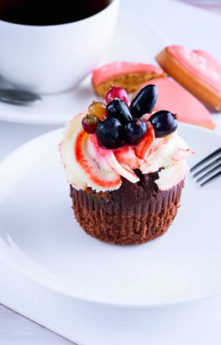 Masanın üzerinde beyaz bir tabak lezzetli kek ile güzel kokulu çay