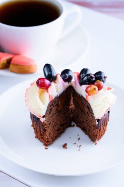 Masanın üzerinde beyaz bir tabak lezzetli kek ile güzel kokulu çay