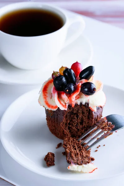 Masanın üzerinde beyaz bir tabak lezzetli kek ile güzel kokulu çay