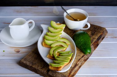 Avokado ve çay ile kahvaltıda kızarmış ekmek