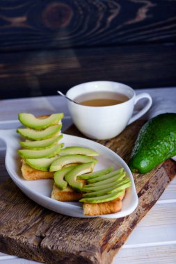 Avokado ve çay ile kahvaltıda kızarmış ekmek