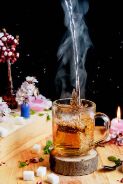 Su sıçramalarına ve çiçeklerle masada sıcak çay