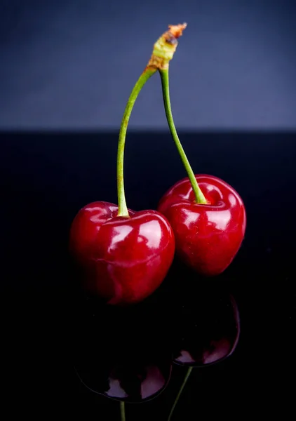 Cerezas dulces maduras y jugosas sobre un fondo oscuro — Foto de Stock
