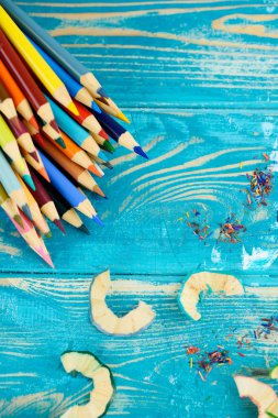 Ahşap arka plan üzerinde yaratıcı çalışma için çok renkli kalemler.