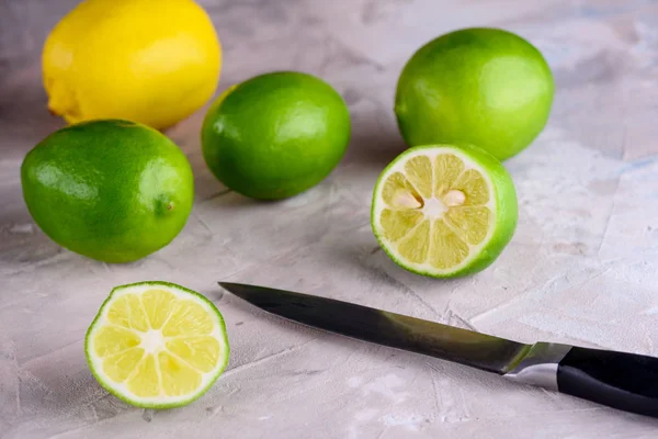 Juicy and fragrant lemons. Green and yellow lemons on a concrete background. Green lemons on a blue background.