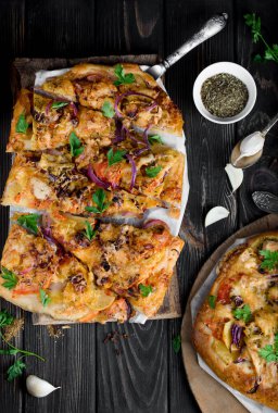 Lezzetli ve iştah açıcı pizza hamur mayaları üzerinden. Lezzetli sebze pizza. Siyah ahşap bir masa üzerinde sebze pizza.