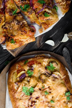 Lezzetli ve iştah açıcı pizza hamur mayaları üzerinden. Lezzetli sebze pizza. Siyah ahşap bir masa üzerinde sebze pizza.