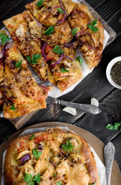 Lezzetli ve iştah açıcı pizza hamur mayaları üzerinden. Lezzetli sebze pizza. Siyah ahşap bir masa üzerinde sebze pizza.