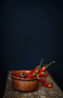 Acı kırmızı biber rustik tarzda bir ahşap tahta üzerinde. Kırmızı acı biber ve koyu arka plan.