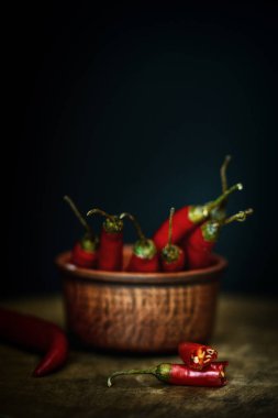 Acı kırmızı biber rustik tarzda bir ahşap tahta üzerinde. Kırmızı acı biber ve koyu arka plan.