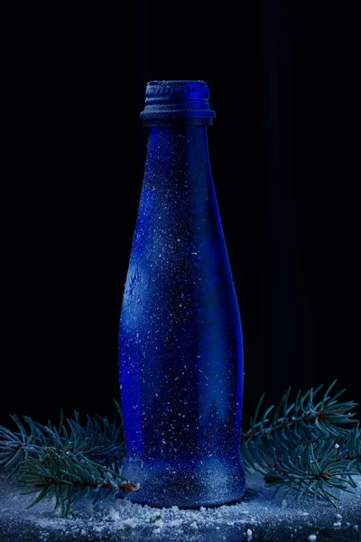 Синяя Стеклянная Бутылка Выстрелил Черный Фон Ветвями Ели Снега — стоковое фото