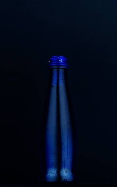 Siyah bir zemin üzerine mavi güzel şişe