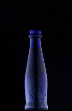 Mavi bir arka plan ışığı atış mavi cam şişe