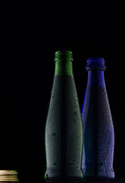 Зеленый Синий Стеклянные Бутылки Выстрел Черном Фоне Свету — стоковое фото