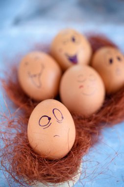 Paskalya yumurtaları mavi bir arka plan üzerinde komik küçük eşek. Yumurta farklı yüzleri. Duygular. Grims. Emoji.