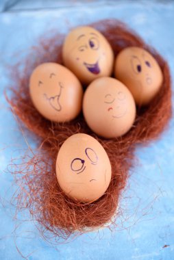 Paskalya yumurtaları mavi bir arka plan üzerinde komik küçük eşek. Yumurta farklı yüzleri. Duygular. Grims. Emoji.