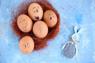 Paskalya yumurtaları mavi bir arka plan üzerinde komik küçük eşek. Yumurta farklı yüzleri. Duygular. Grims. Emoji.