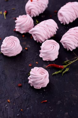 Lezzetli, lezzetli, pikatny tatlı. Marshmallow ile siyah bir zemin üzerine kırmızı biber lezzet.