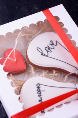 Bir kalp ve ampul, lezzetli şeklinde kokulu tatlım pasta krema. Zencefilli kurabiye. Tatlı. Karanlık bir arka plan üzerinde davranır.