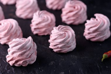 Baharatlı tatlı kırmızı biber ile. Hatmi lezzetli ve iştah açıcı marshmallow ile siyah bir zemin üzerine kırmızı biber tat.