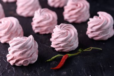 Baharatlı tatlı kırmızı biber ile. Hatmi lezzetli ve iştah açıcı marshmallow ile siyah bir zemin üzerine kırmızı biber tat.