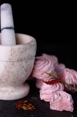 Baharatlı tatlı kırmızı biber ile. Hatmi lezzetli ve iştah açıcı marshmallow ile siyah bir zemin üzerine kırmızı biber tat.