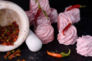 Baharatlı tatlı kırmızı biber ile. Hatmi lezzetli ve iştah açıcı marshmallow ile siyah bir zemin üzerine kırmızı biber tat.