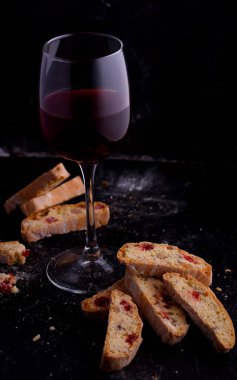 Kurutulmuş kiraz ve fındık ile lezzetli bisküvi kurabiye. Organik tarzı. Bir bardak kırmızı şarap.