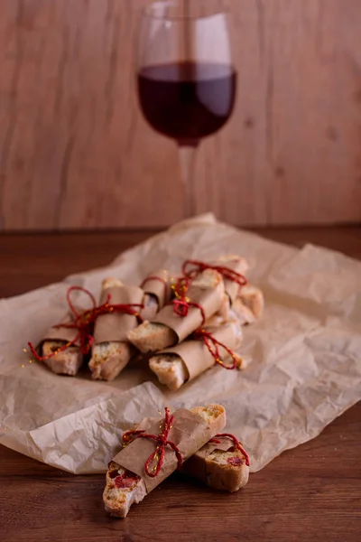 Delicious biscotti cookies with dried cherries and hazelnuts. Organic style. A glass of red wine.